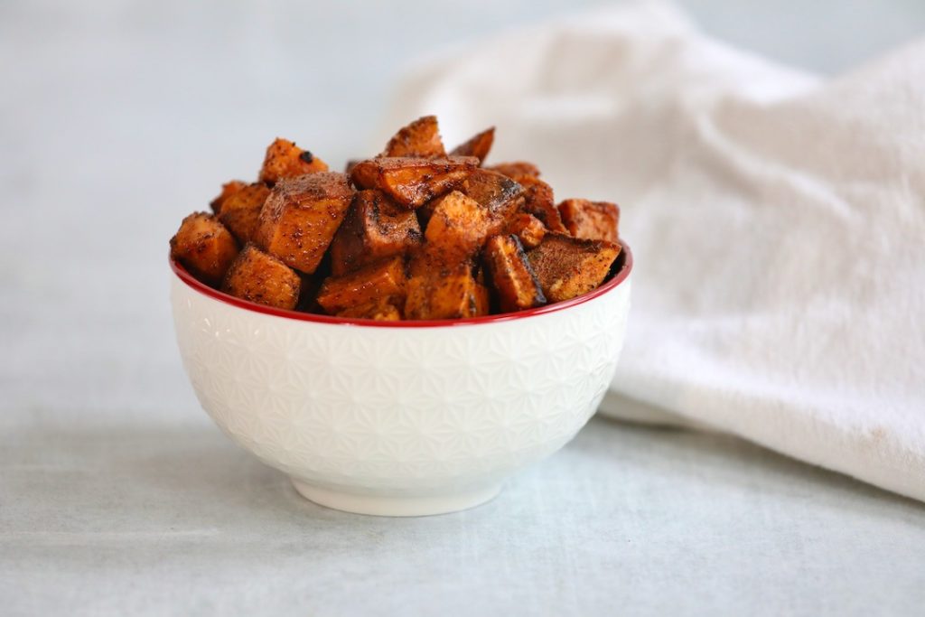 Roasted diced sweet potatoes in a white bowl