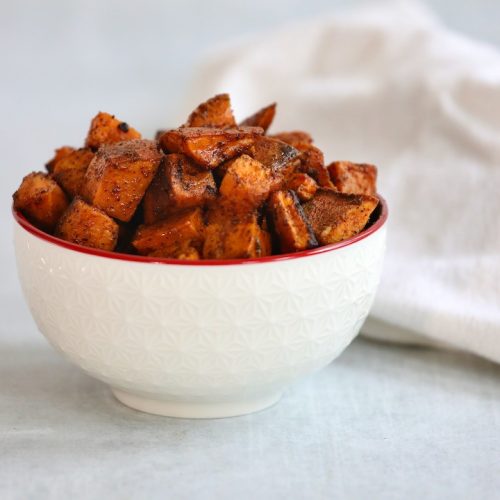 Roasted diced sweet potatoes in a white bowl