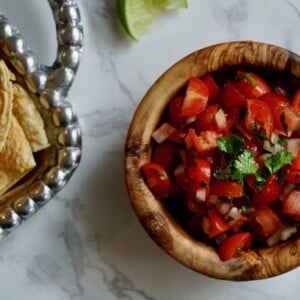 fresh cherry tomato salsa in a wooden bowl with a side of tortilla chips