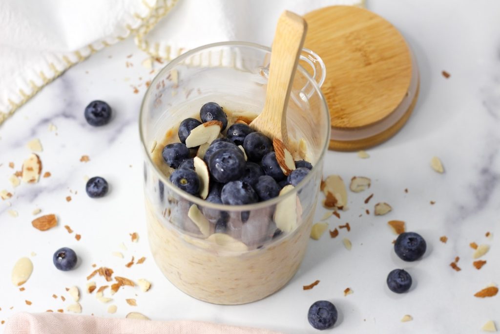 blueberry overnight oats in a clear cup with almonds