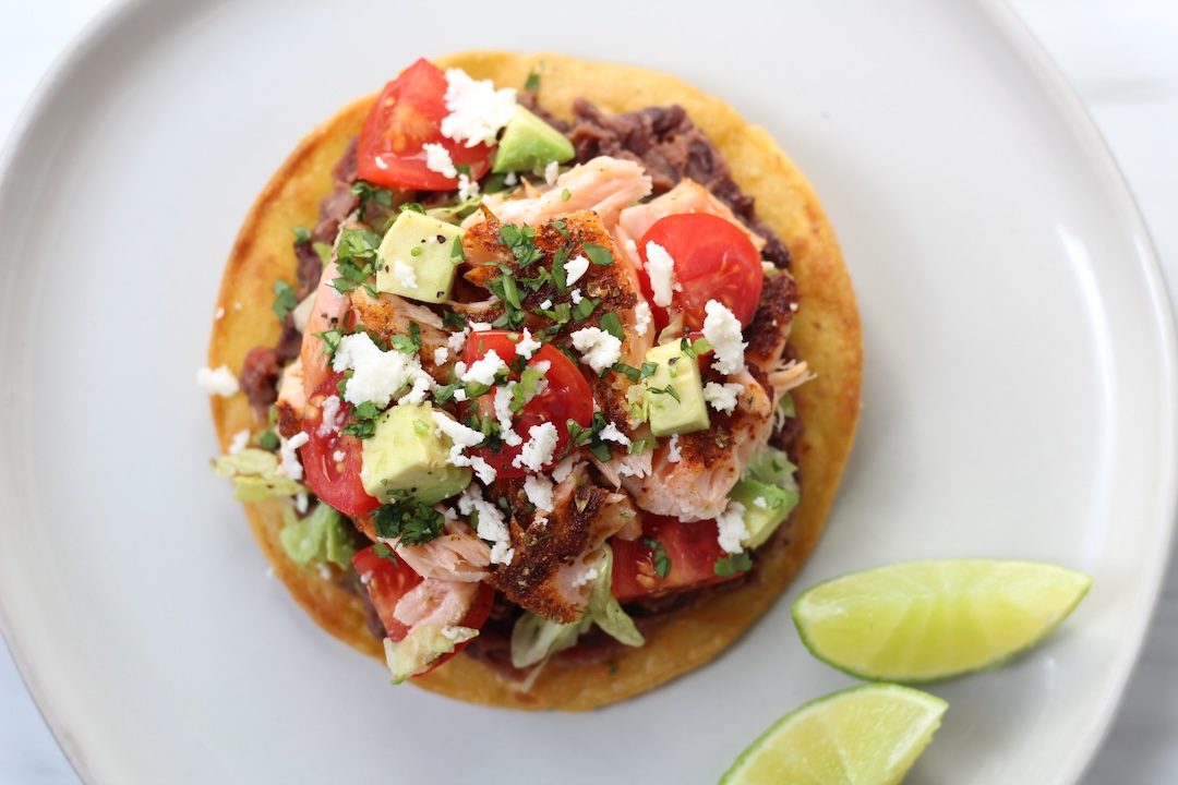 salmon tostadas with fresh vegetables - lettuce, tomatoes, avocado