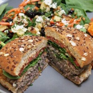 beef and bean burgers base recipe on a plate with roasted sweet potatoes and a side salad