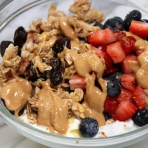 greek yogurt parfait base recipe with nut butter and berries in a clear glass bowl