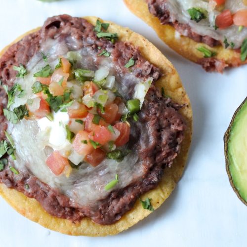 Bean and Cheese Tostadas with half an avocado