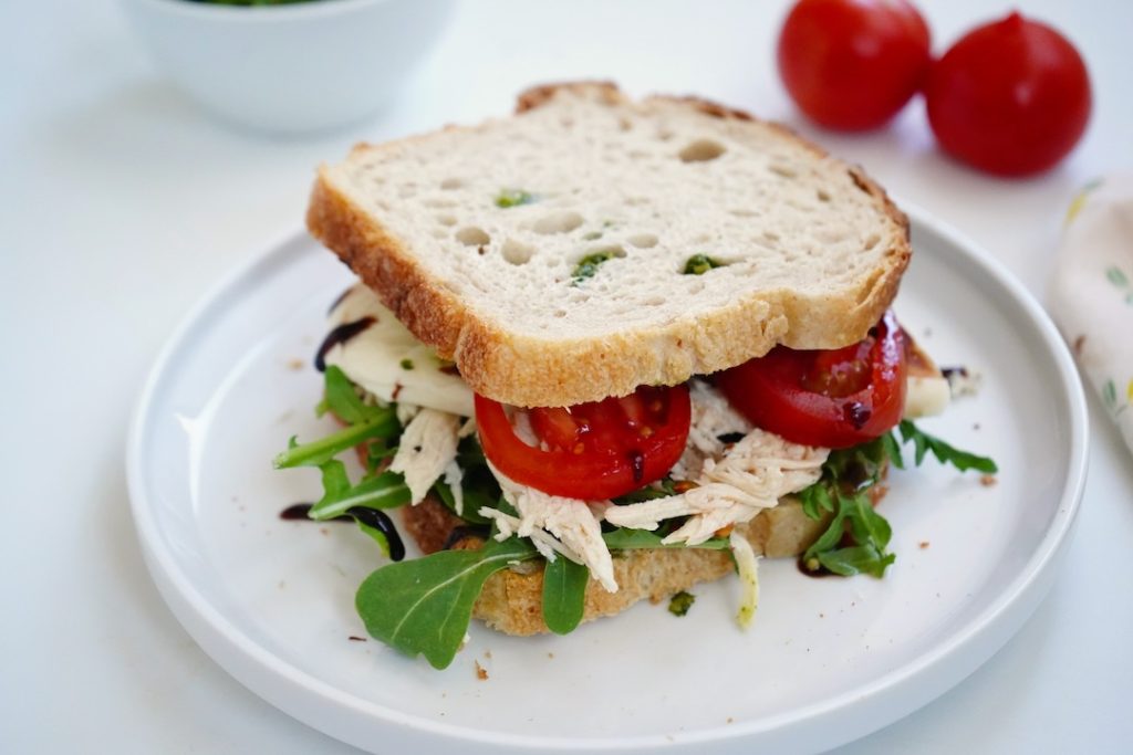 caprese chicken sandwich on a white plate