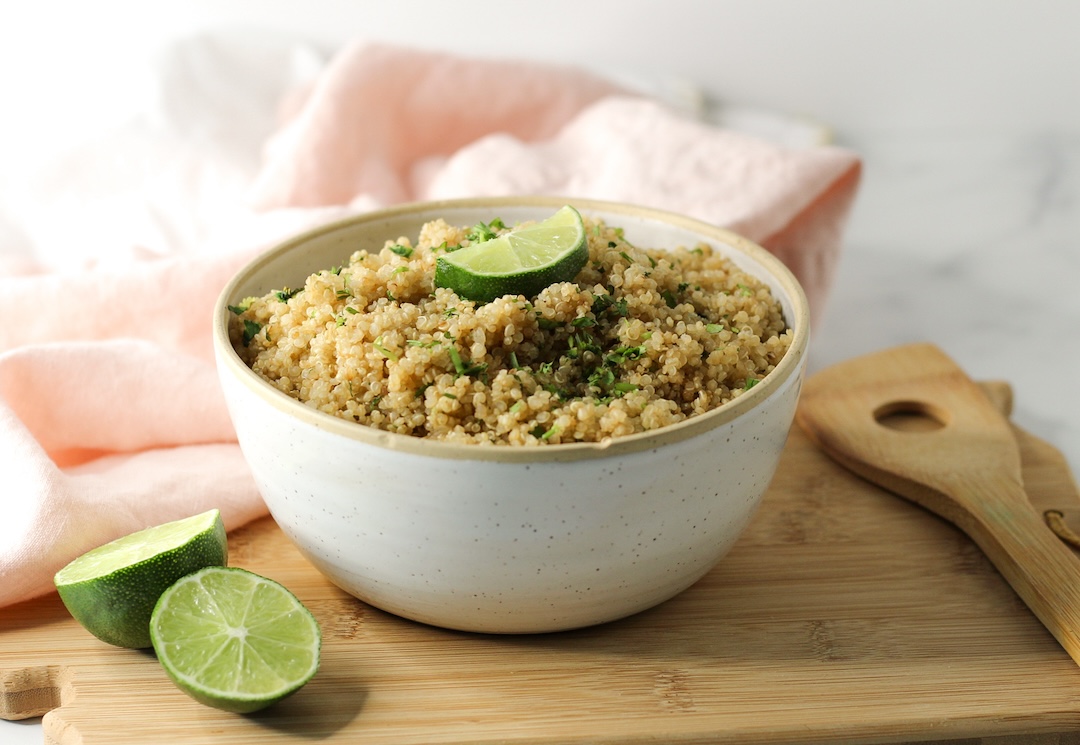 cilantro lime quinoa in a bowl topped with fresh lime