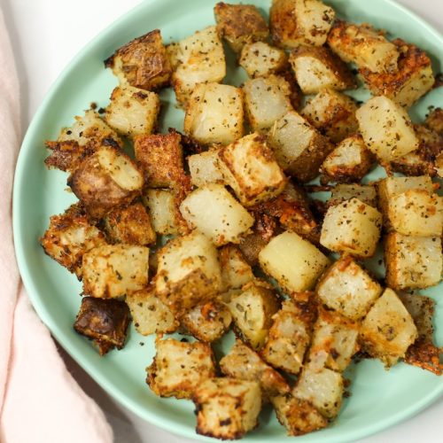 parmesan garlic roasted potatoes on a teal plate