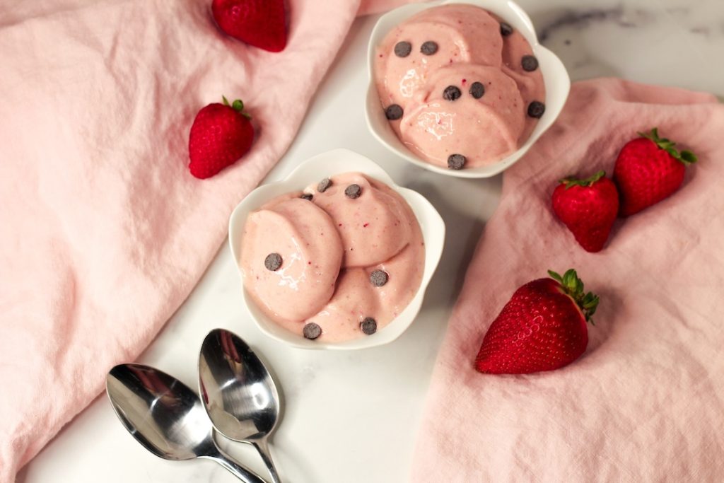 strawberry nice cream sprinkled with chocolate chips in two white bowls