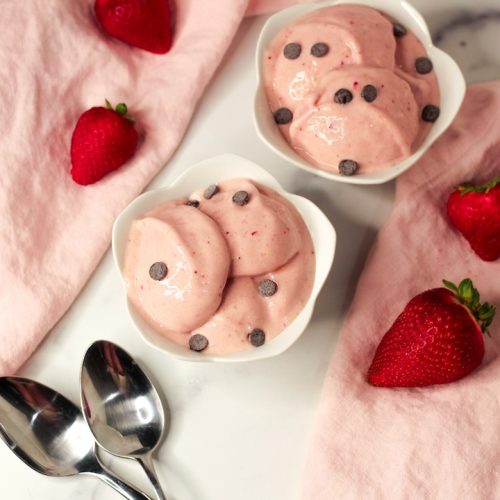 strawberry nice cream sprinkled with chocolate chips in two white bowls