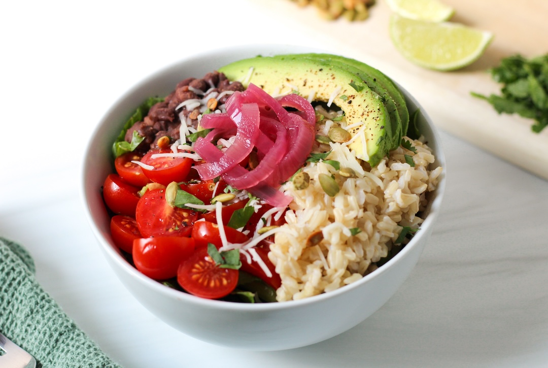 Vegetarian Burrito Bowl made with black beans, brown rice, avocado, pico de gallo, and pickled onions