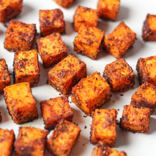 Diced sweet and spicy roasted sweet potatoes on a white surface