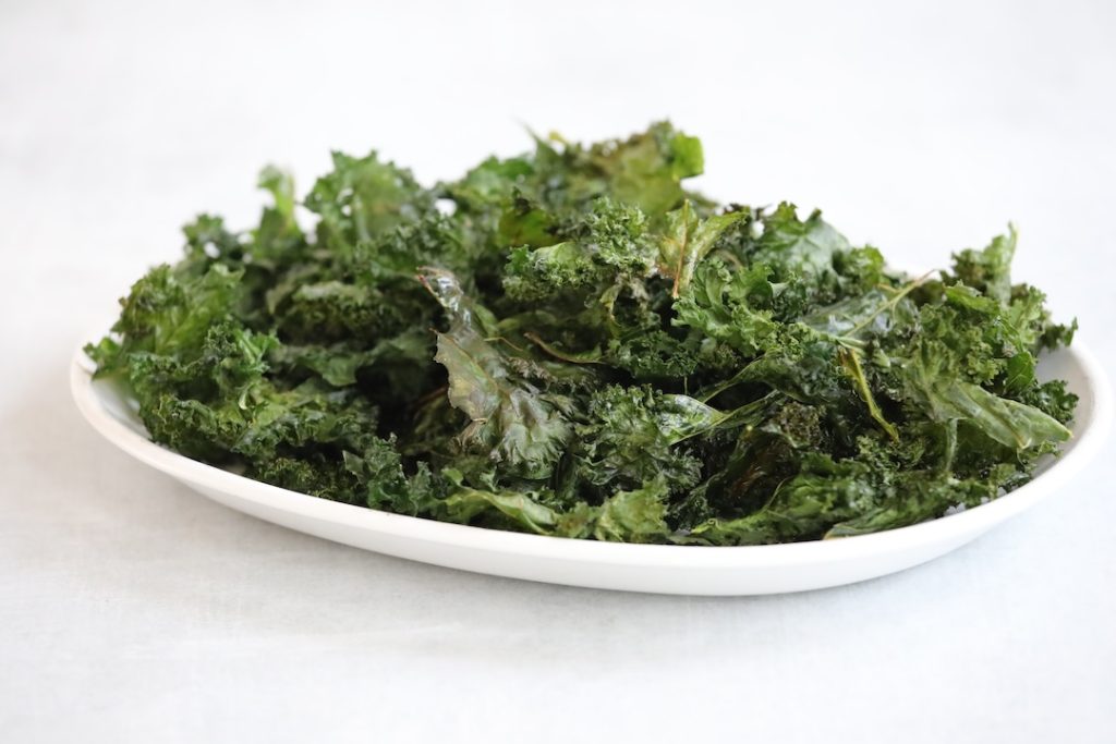 garlic kale chips on a white plate